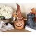 This image shows a Halloween witch decoration. It is made from a real dried gourd. Her name is Beatrice and has an orange witch hat.